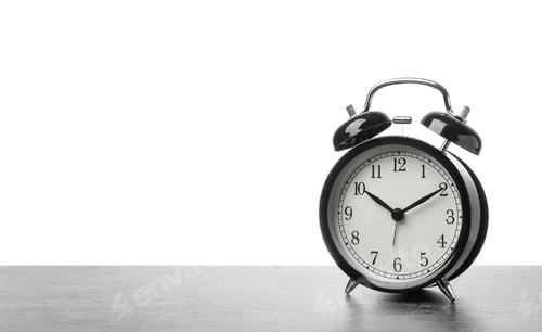 Preview: Alarm clock on table against white background. Time concept