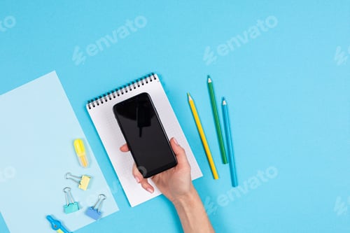 Preview: Mobile phone and different stationery isolated on whitte and blue background