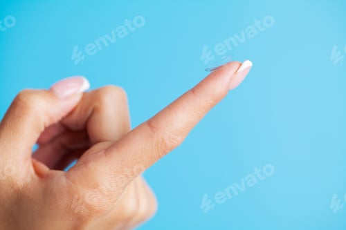 Preview: Solving vision problems, close up of woman holding contact lens