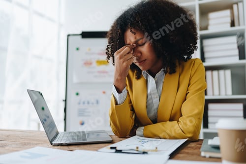 Preview: Burnout American African business woman in stress works with many paperwork document, migraine