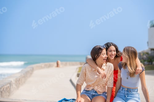 Preview: Three friends laughing happily on a day at the beach