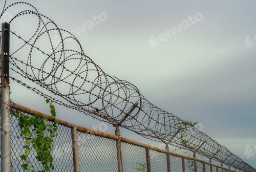 Preview: Prison security fence. Barbed wire security fence. Razor wire jail fence. Barrier border. Boundary s