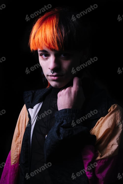 Preview: Portrait with black background of a young man with orange painted hair.
