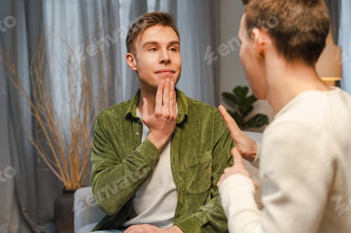 Preview: Two male friends learning sign language at home. nonverbal communication