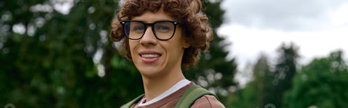 Preview: Handsome young student enjoys a leisurely walk in a serene outdoor setting filled with greenery