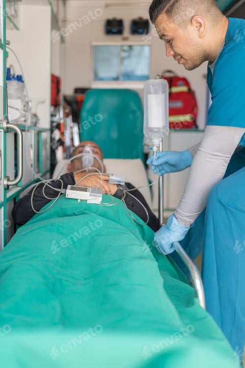 Preview: Doctor administering intravenous medicine to a patient inside an ambulance