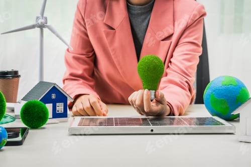 Preview: Female entrepreneur working at desk in clean energy sector Focusing on wind turbines solar energy