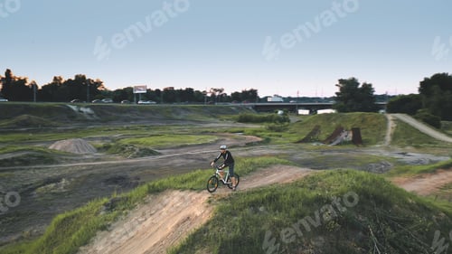 Preview: Closeup man drive bicycle on dirt road aerial. Summer nature landscape. Young traveler ride on bike