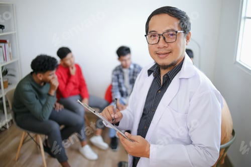 Preview: POV Smiling Psychologist Man Posing While Looking at Camera Against Blurry People Background