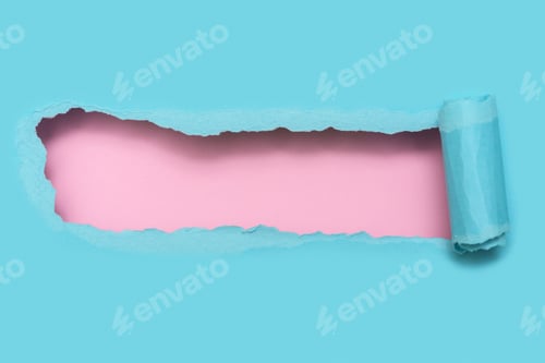 Preview: Torn blue paper with pink space for text. Top view.
