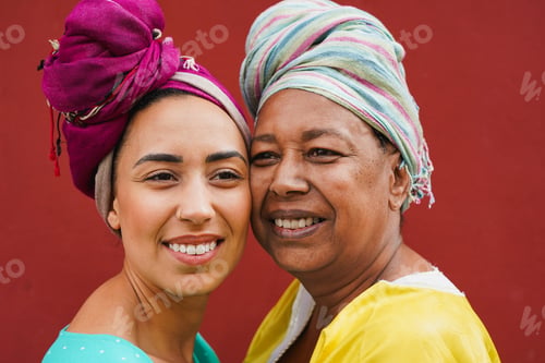 Preview: Happy african mother and adult daughter having tender moment in front of camera