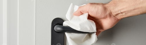 Preview: partial view of man cleaning metal door handle with napkin, panoramic shot