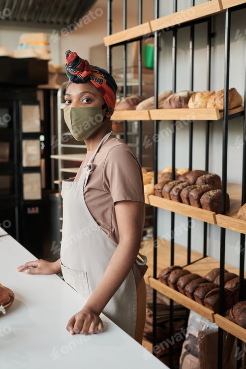 Preview: Baker in mask working in bakery