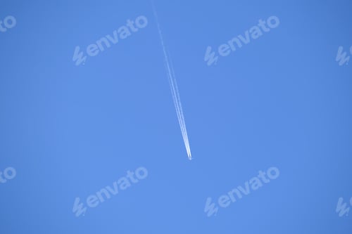 Preview: Distant passenger jet plane flying on high altitude on clear blue sky leaving white smoke