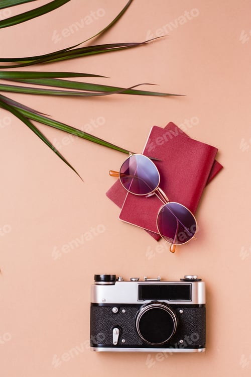 Preview: Bright travel flat lay with sunglasses, passports and a vintage camera on a beige background.