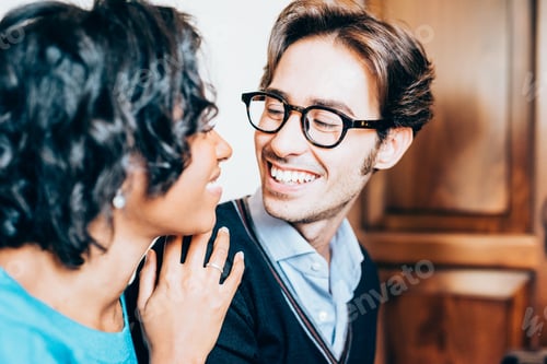 Preview: multiethnic couple of lover looking one in the other's eye, smiling