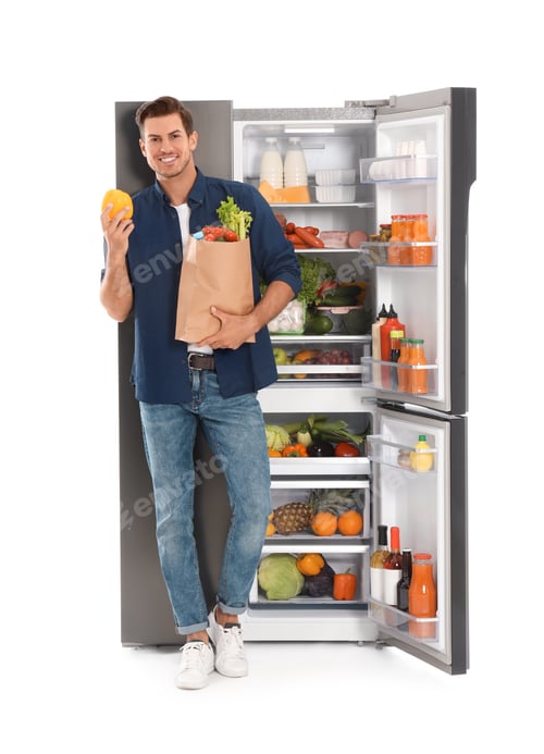 Preview: Man with bag of groceries near open refrigerator on white background