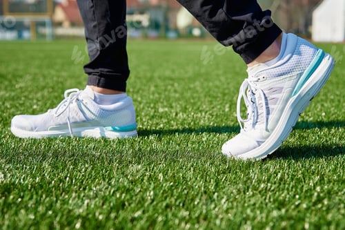 Preview: Runner feet running at stadium with green grass