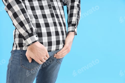 Preview: Man holds ass on blue background. Hemorrhoids concept