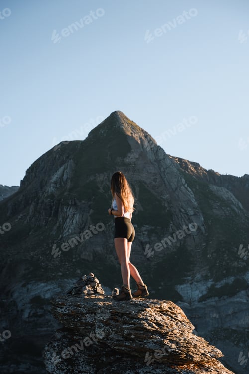 Preview: young girl looking at the mountain climbed on a rock during her trip through the pyrenees