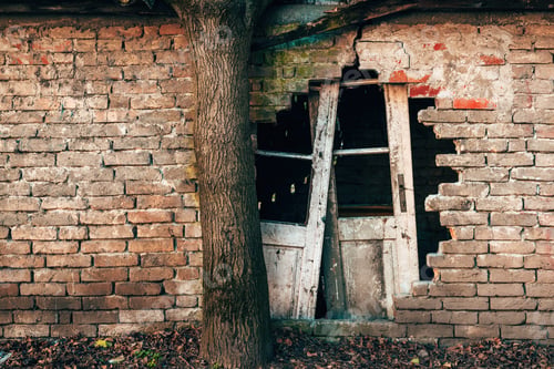 Preview: Old ruined house with damaged brick wall and broken doors