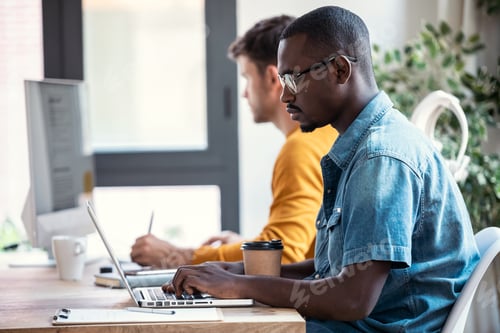 Preview: Two concentrated graphic designer working with computer in modern startup office.