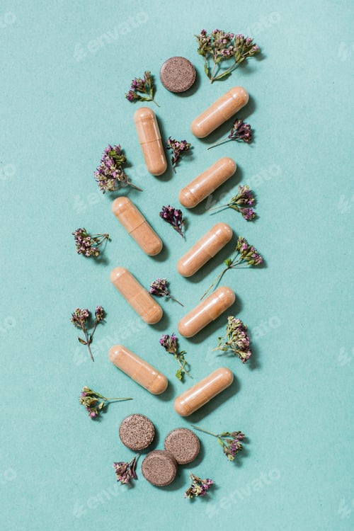Preview: Medicinal capsules, pills and herbs in the form of a branch on a green background.