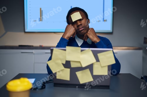 Preview: Stressed manager works on laptop, night office