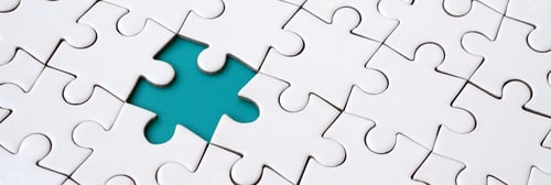 Preview: Close-up texture of a white jigsaw puzzle in assembled state with missing elements forming a