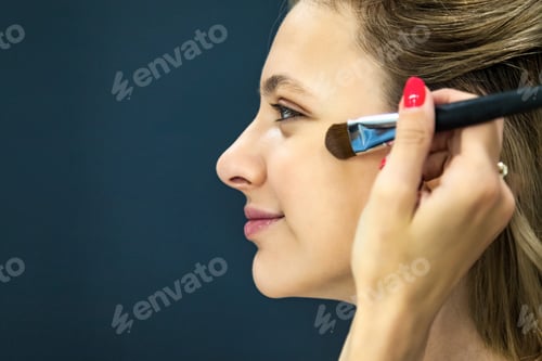 Preview: Makeup artist doing professional make up of young woman creating look in beauty salon