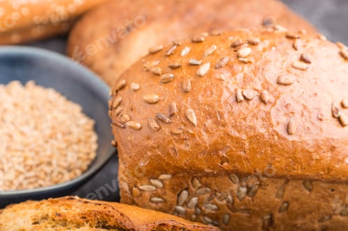 Preview: Different kinds of fresh baked bread on a black concrete background. side view, selective focus.