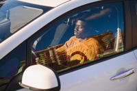 Preview: African American driving an electric car.