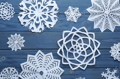 Preview: Flat lay composition with paper snowflakes on blue wooden background. Winter season
