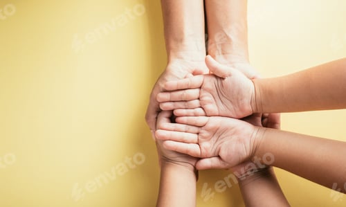 Preview: Studio shot, Close-up top view of family hands stacked on isolated background. Parents and kid hold