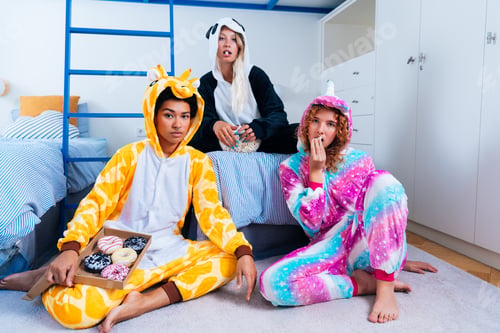 Preview: Multiethnic group of young female friends having pajamas party at home