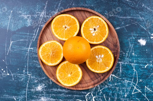 Preview: Sliced oranges and mandarines on a wooden platter, top view