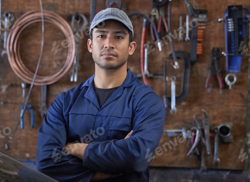 Preview: Cropped portrait of a handsome young male mechanic standing with his arms folded in his workshop
