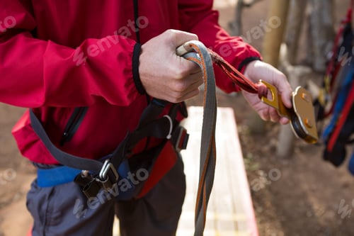 Preview: Hiker man adjusting his harness in the forest
