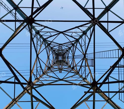 Preview: Low angle of a transmission tower under the blue sky