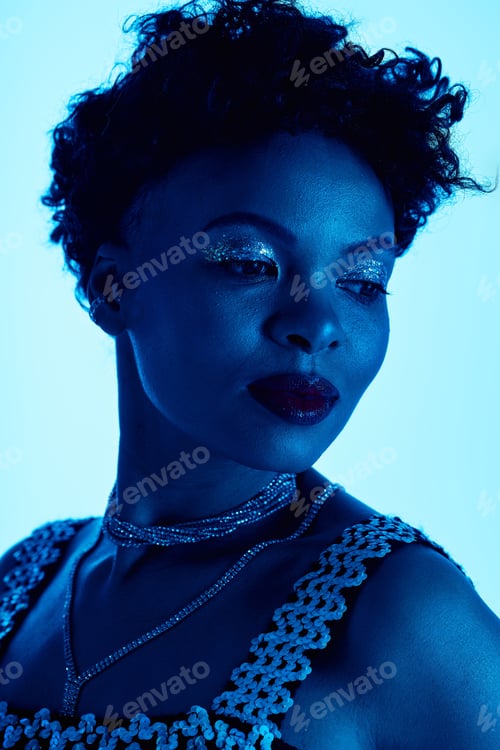 Preview: Stylish african american woman showcases modern fashion in vibrant blue lighting
