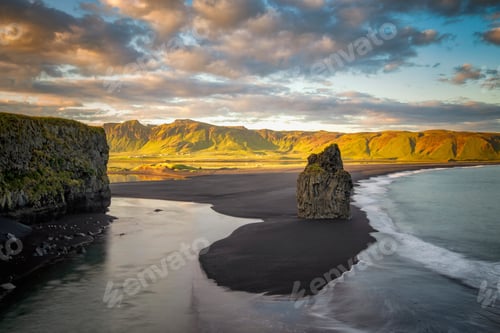 Preview: Golden hour view of a serene black sand beach with dramatic cliffs and a solitary sea stack