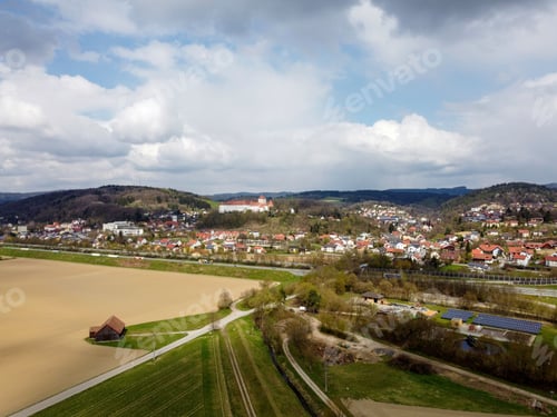 Preview: Aerial of fields an a town under a blue cloudy sky.