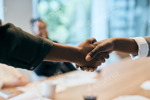 Preview: Closeup of two unrecognizable businesspeople shaking hands in the office at work during the day