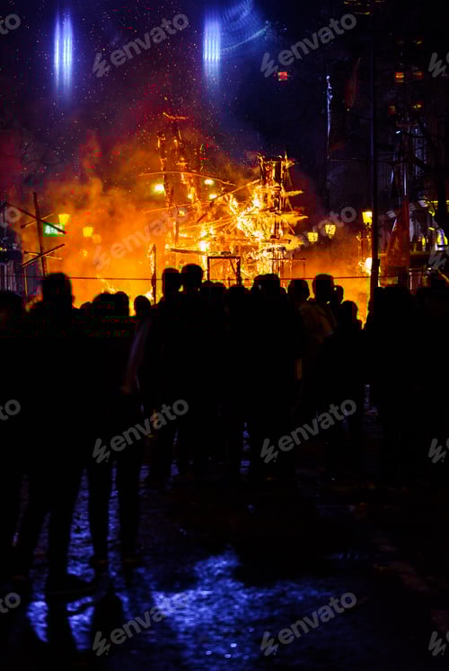 Preview: Group of people contemplating how a cardboard monument burns in Valencian Fallas.