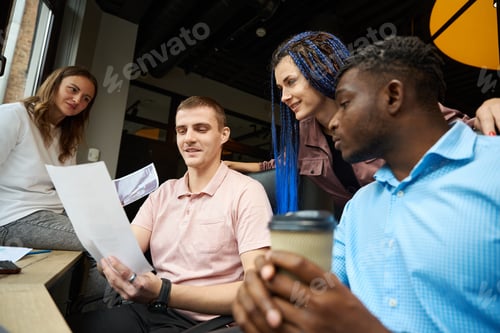 Preview: Creative team reading the contract sitting in workplaces