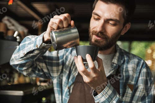Bearded Barista Pouring Milk into Coffee Cup
