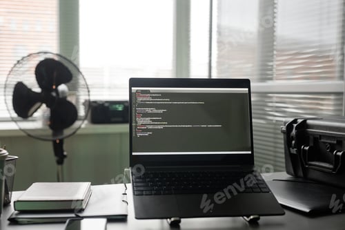 Preview: Laptop with Programming Language on Screen Standing on Developers Desk in Office