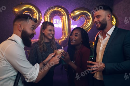 Visualização: Feliz grupo de amigos celebra a véspera de Ano Novo e trocam presentes