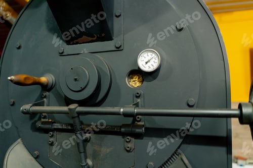 Preview: close-up at coffee roasting factory you can see how the coffee rotates through the porthole
