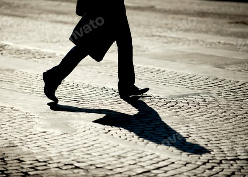 Preview: Legs of person walking on cobblestones